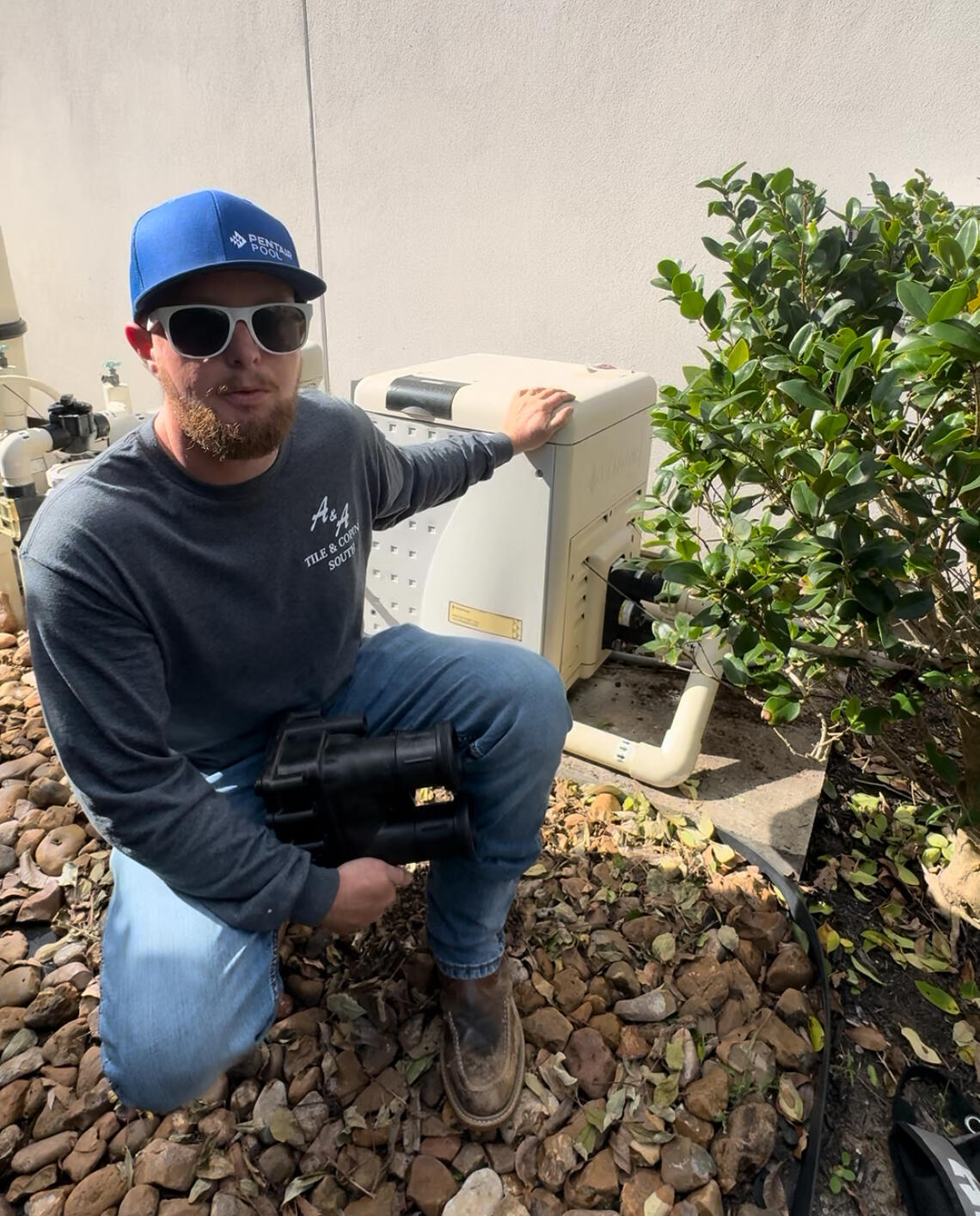 Drew Pools Pool Equipment Specialist in Katy Texas Drew Pools technician standing beside a professionally installed residential pool equipment pad in Katy, Texas.