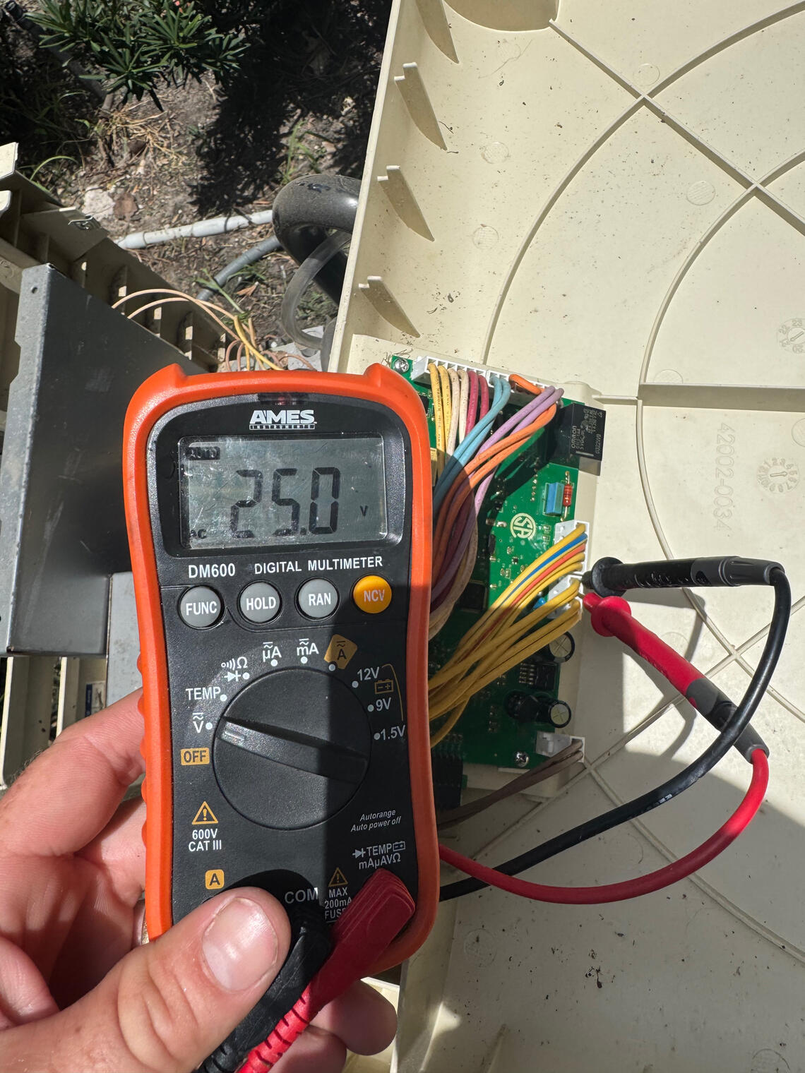 Pool heater control board being diagnosed with a multimeter during professional equipment troubleshooting by Drew Pools in Katy, Texas.